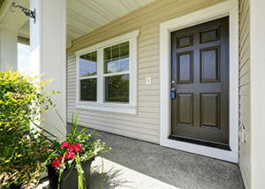 Open porch with concrete floor, column and entrance brown door